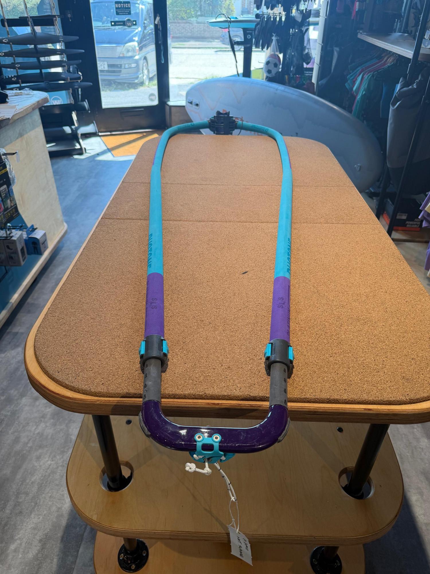 Used Duotone Platinum SLS 160-220 carbon windsurfing boom in blue and purple, featuring an adjustable tail and front end.