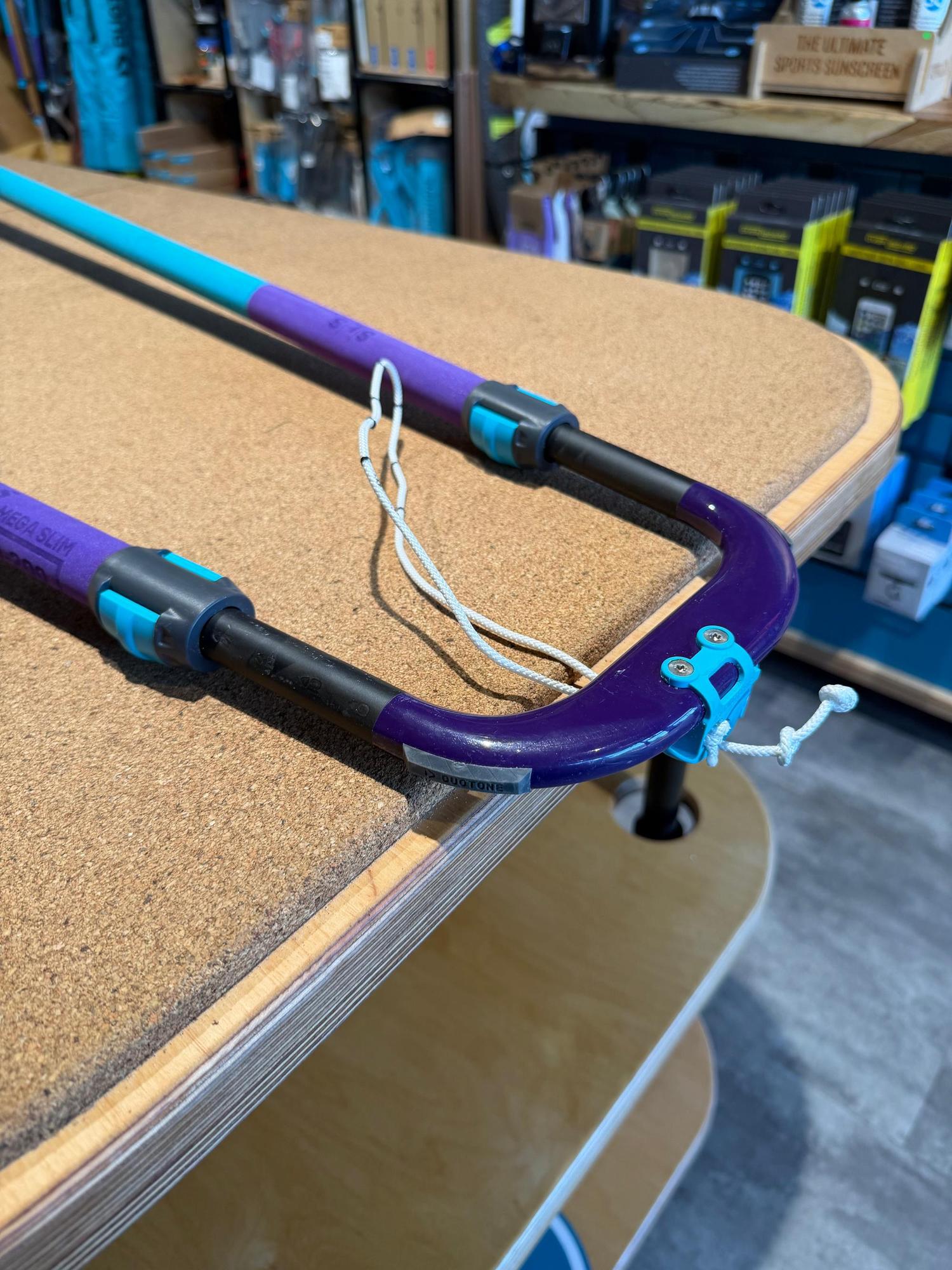 Used Duotone Platinum SLS 140-200 carbon windsurfing boom in purple and teal with adjustable grip and front-end attachment.