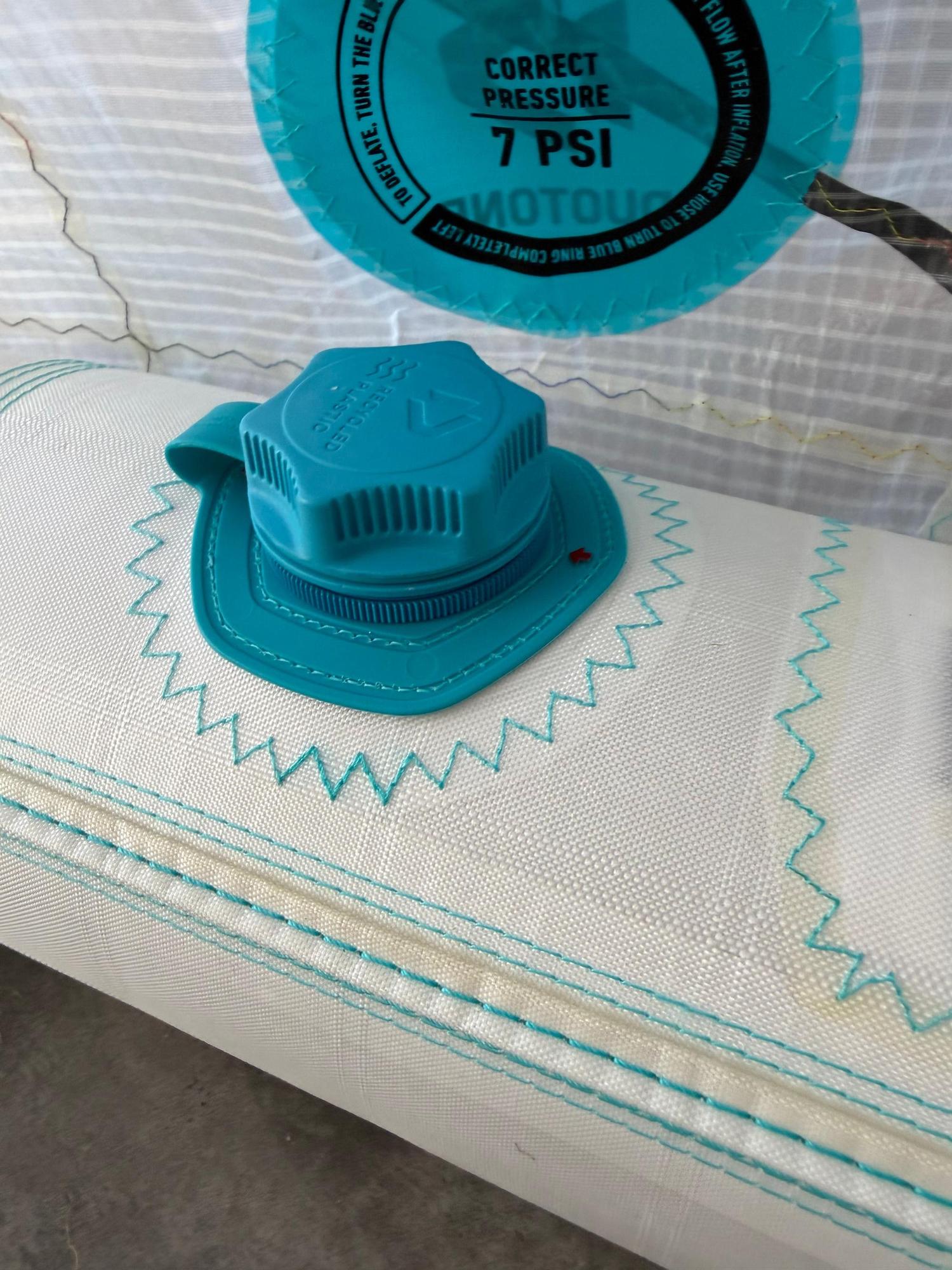 Teal inflation valve on a white Duotone Rebel SLS Concept Blue kite featuring recycled plastic components.
