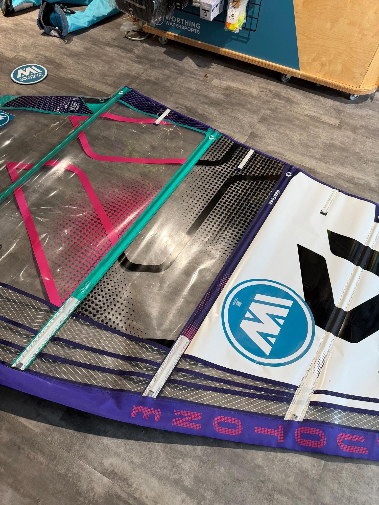 Used Duotone X_Pace 5.8 freerace windsurf sail in purple, pink, and clear monofilm with protective panel detailing.