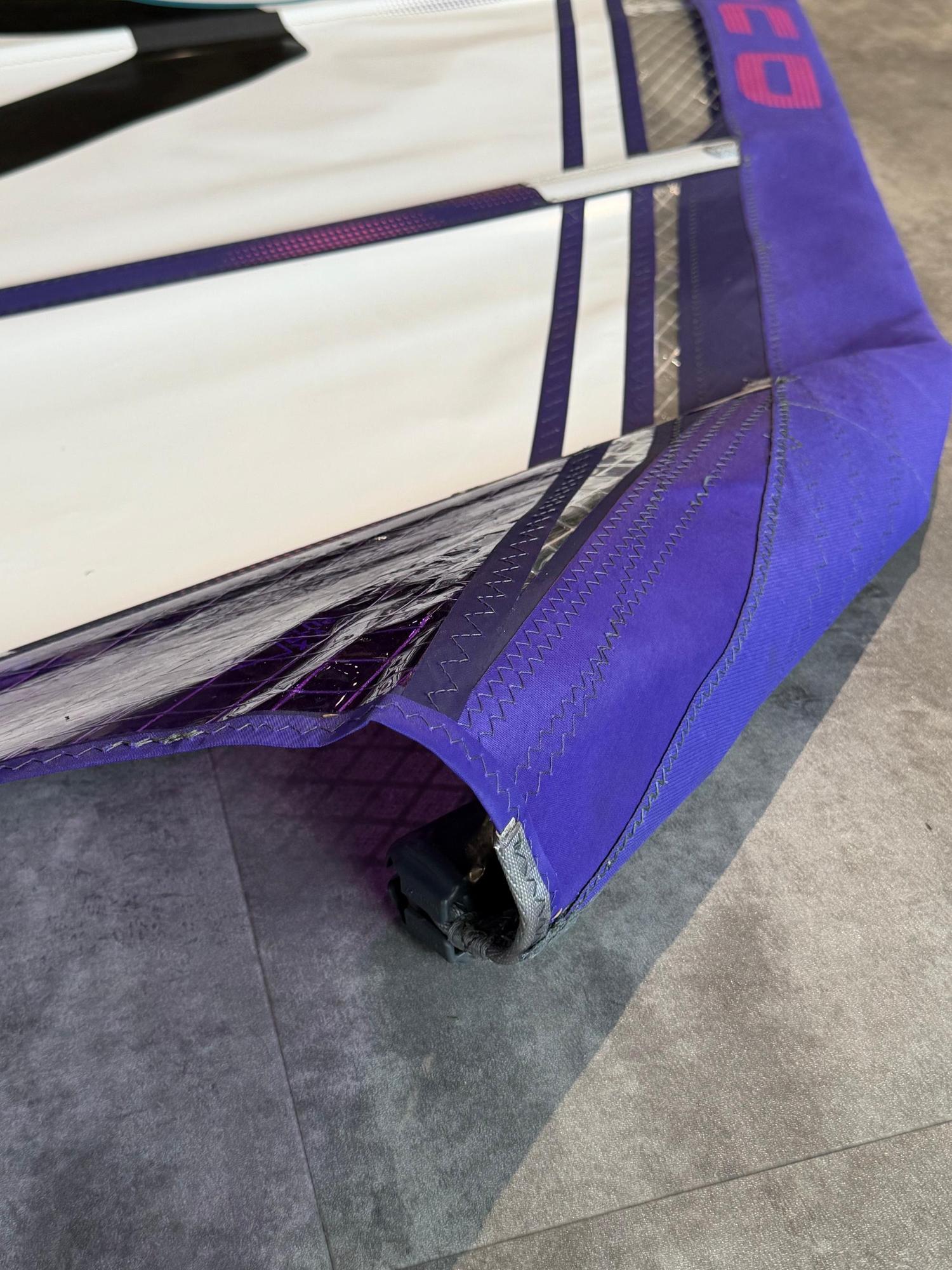 Used Duotone X_Pace 5.8 freerace windsurf sail in white and purple with reinforced sail protectors on the main panel.
