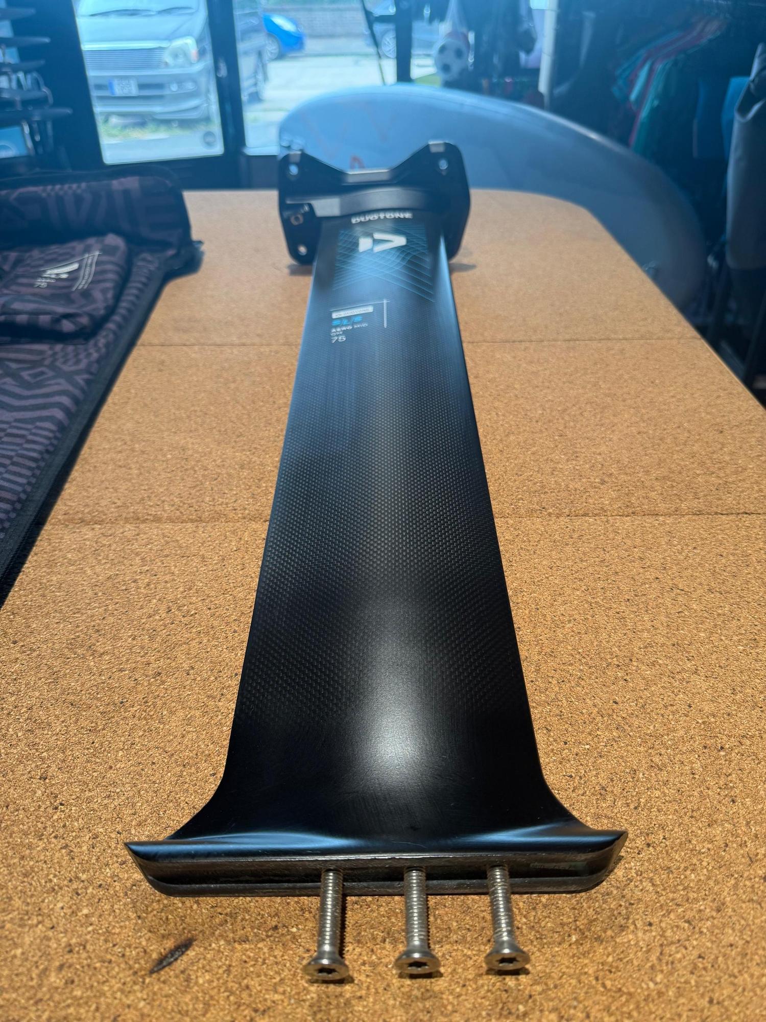 Used Duotone Aero Mid QM SLS 75 carbon foil mast with Quickmount system on a cork surface.