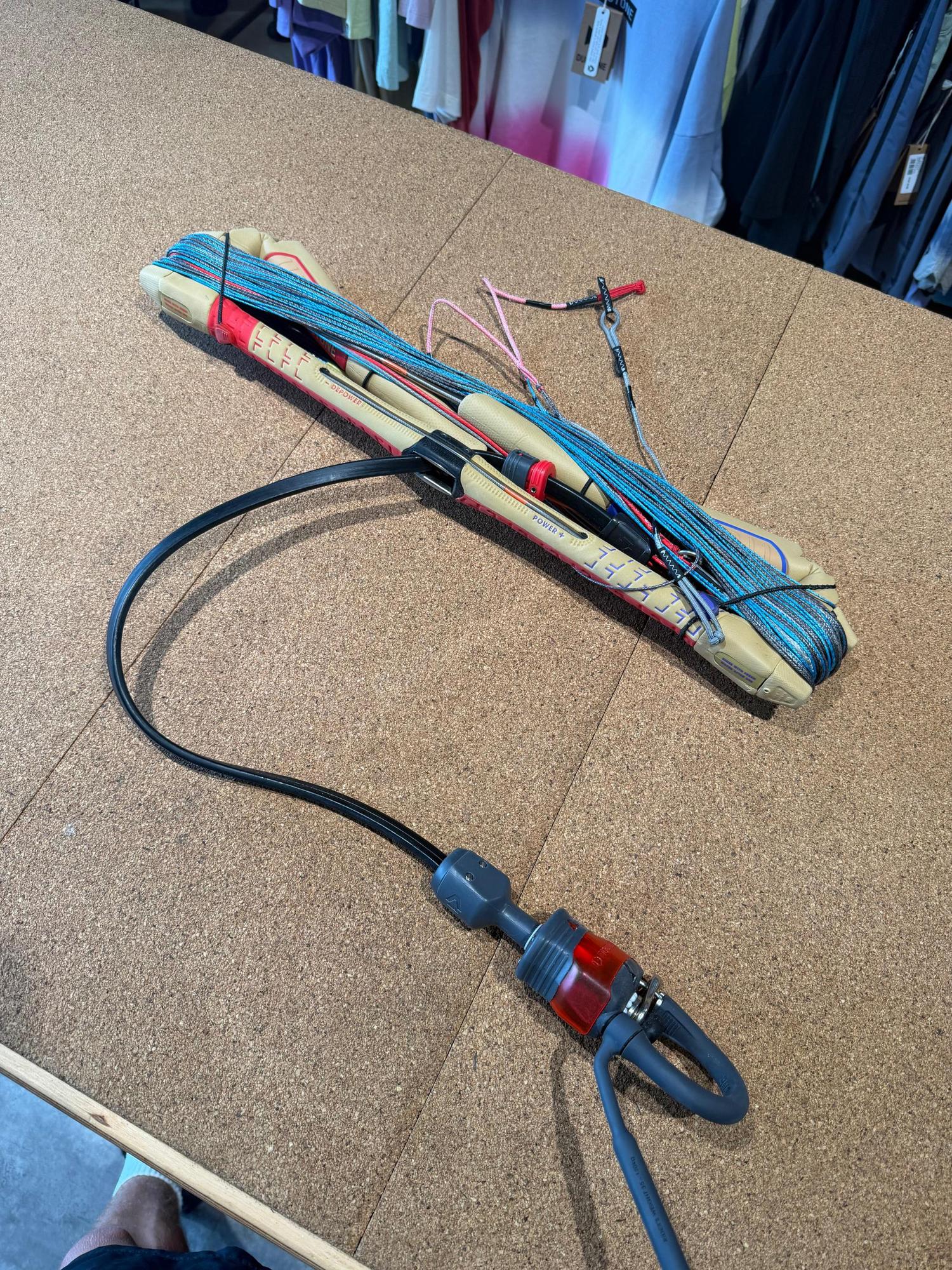 Used Duotone Click Bar Quad Control 2026 S size with tan bar, wound lines, and red Click-In safety system on a cork surface.