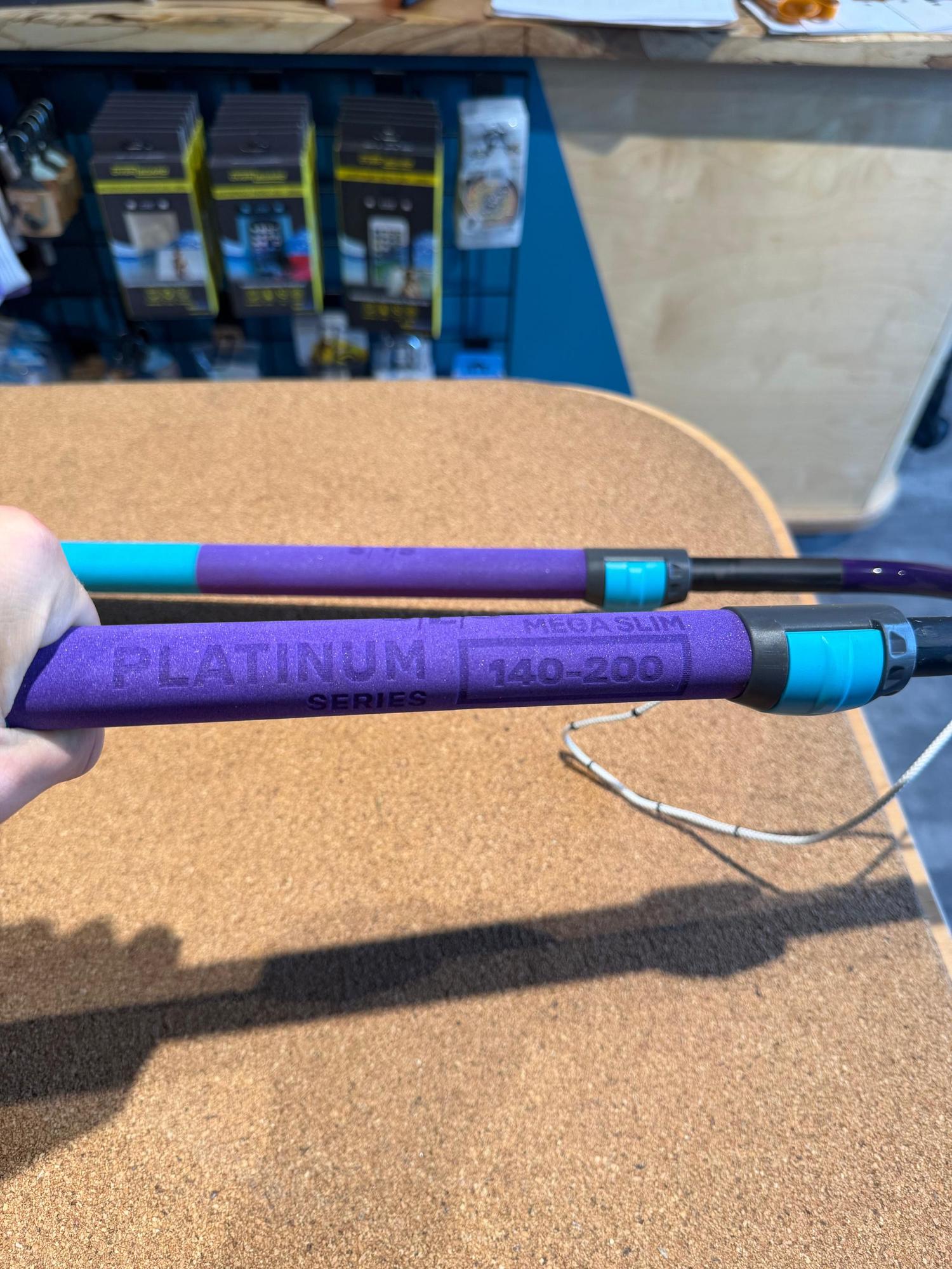 Used Duotone Platinum Series 140-200 carbon windsurfing boom with purple grip and teal adjustment collars.