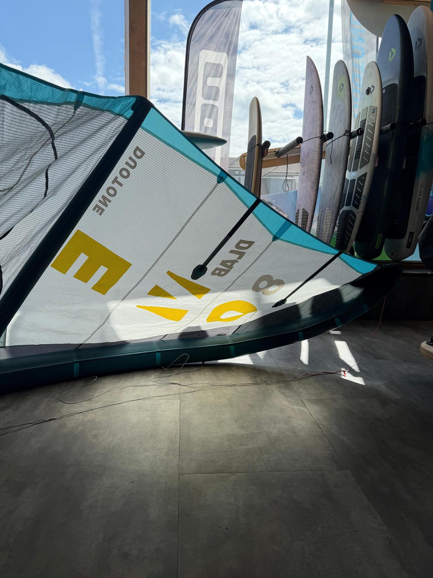 Used 8m Duotone Evo DLAB kite in white, blue, and yellow with Aluula and Trinity TX fabric, displayed indoors.