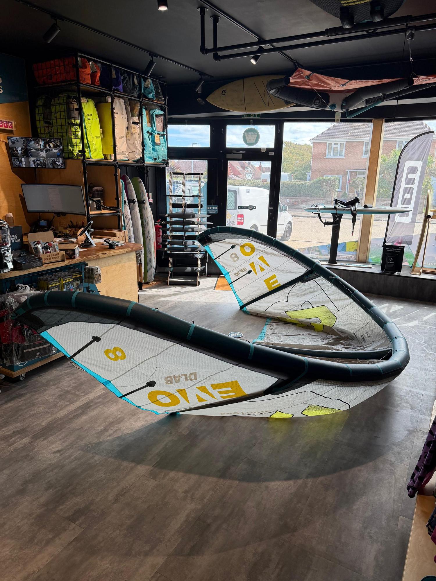 Used 8m Duotone Evo DLAB kite in white and blue with Aluula material, displayed on a shop floor.