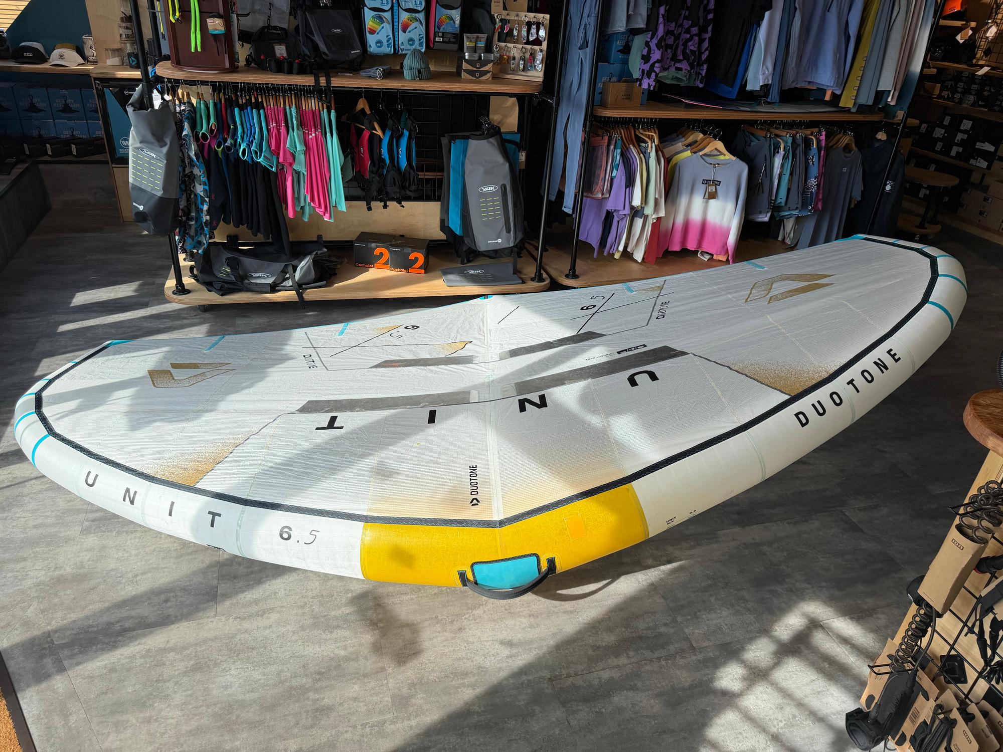 Used 2026 Duotone Unit SLS 6.5m Concept Blue wing in white with yellow and teal accents, featuring a fitted fusion boom.