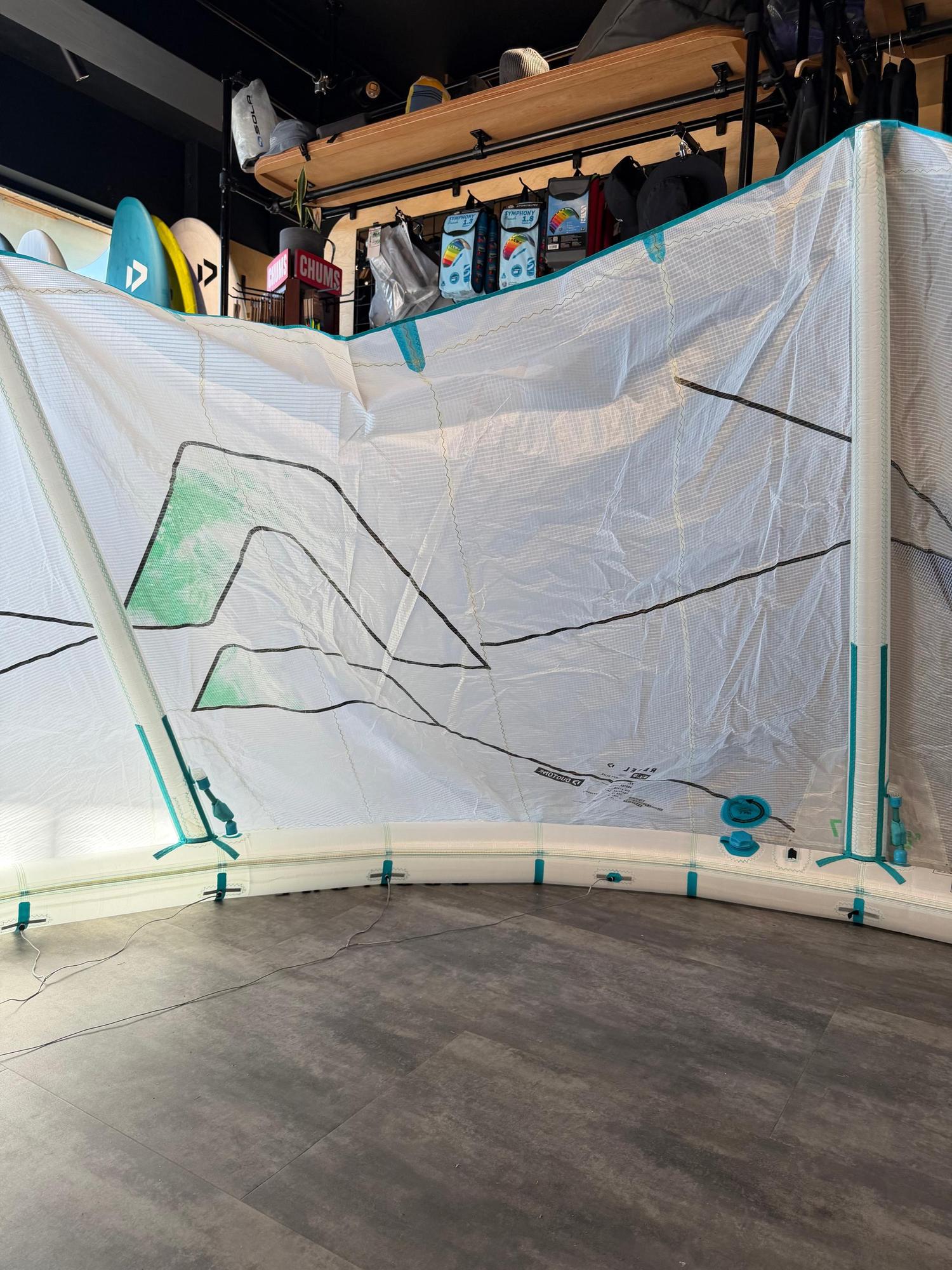 Used 7m Duotone Rebel SLS Concept Blue kite in white with teal accents and Penta TX material, displayed indoors.