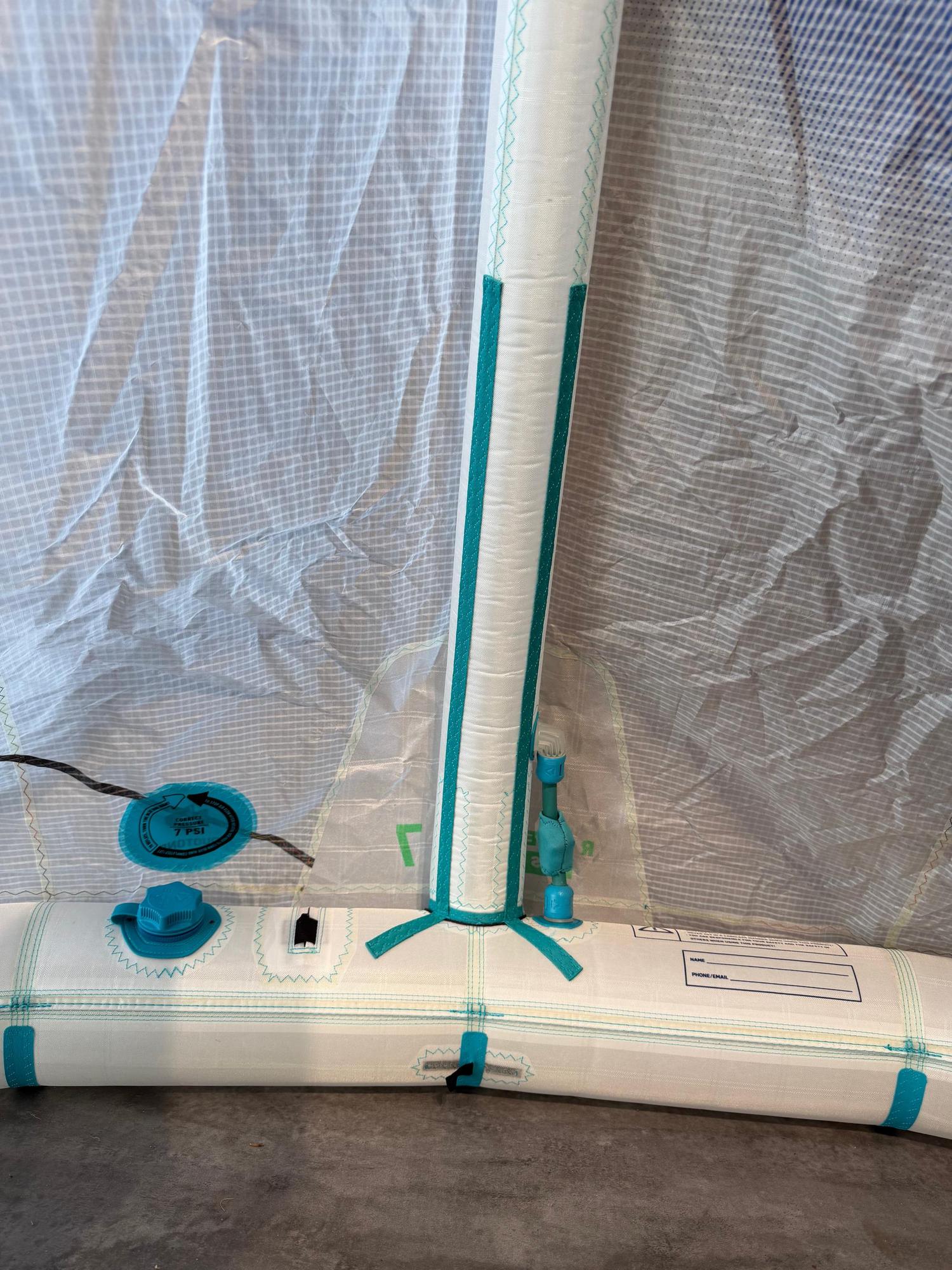 Close-up of a 7m Duotone Rebel SLS Concept Blue kite featuring white undyed fabric, teal accents, and a 7 PSI inflation valve.