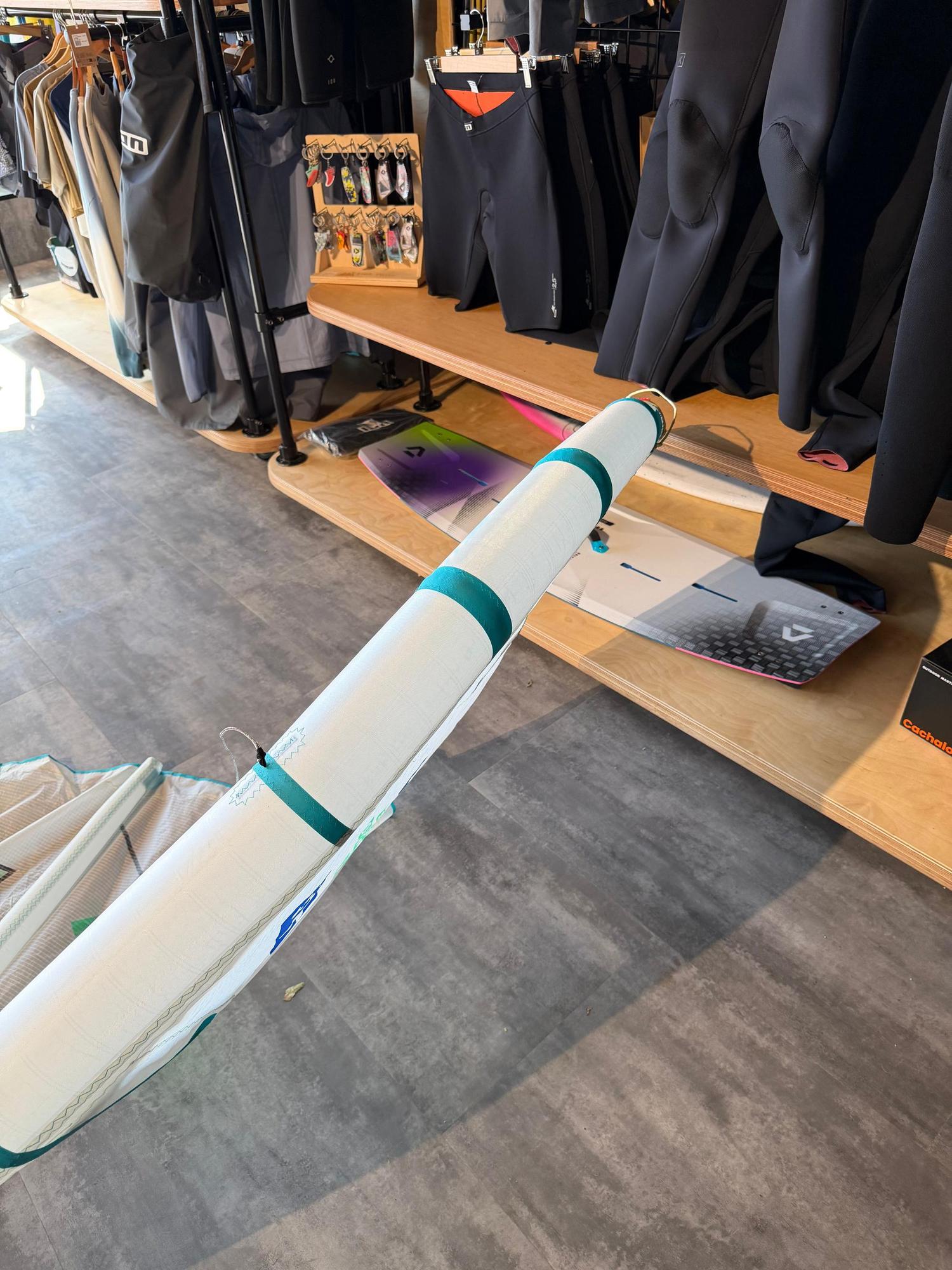 White and teal Duotone Rebel SLS Concept Blue 7m kite leading edge with branded detailing on a shop floor.