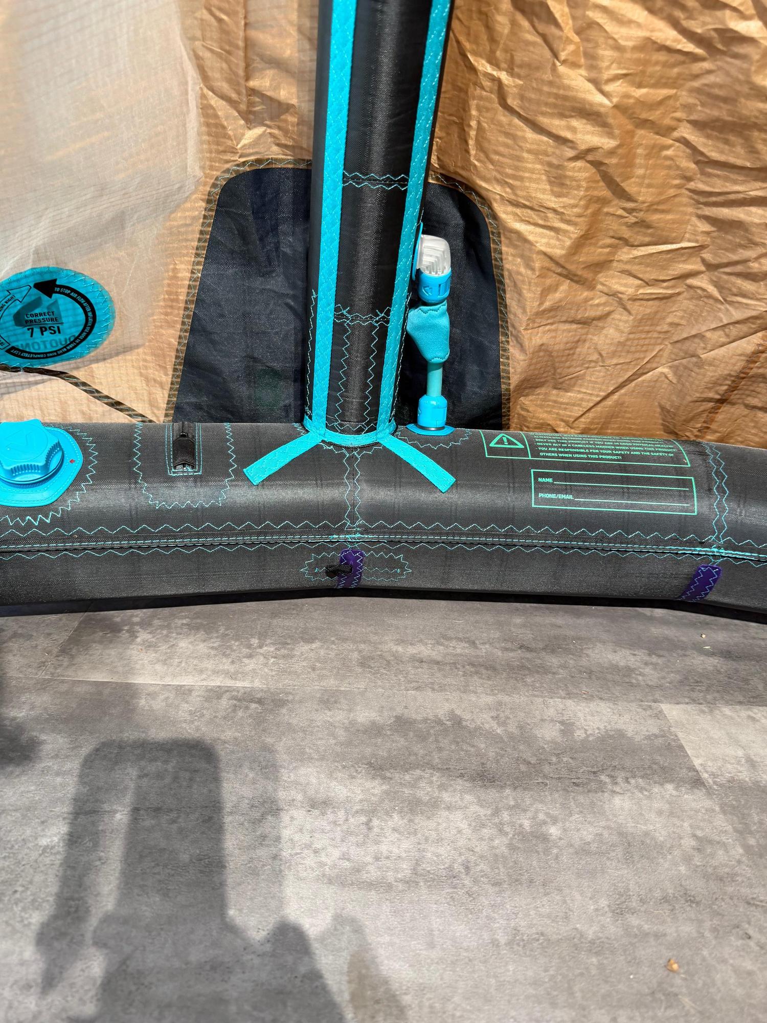 Black and teal Duotone Neo SLS 6m wave kite strut with inflation valve, pressure gauge, and reinforced canopy stitching.
