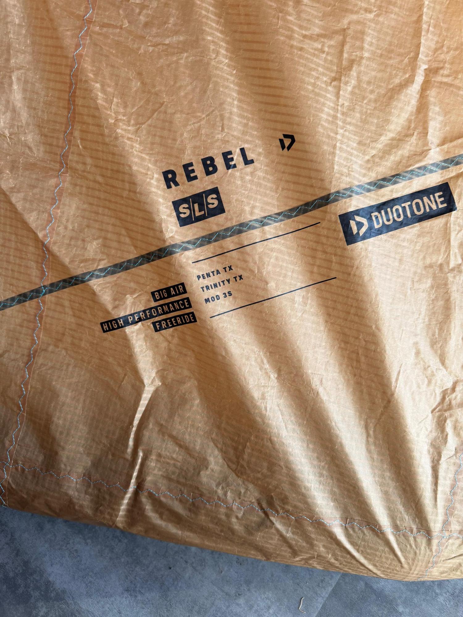 Crispy tan Duotone Rebel SLS 8m kite canopy featuring Penta TX and Trinity TX material branding and big air design details.