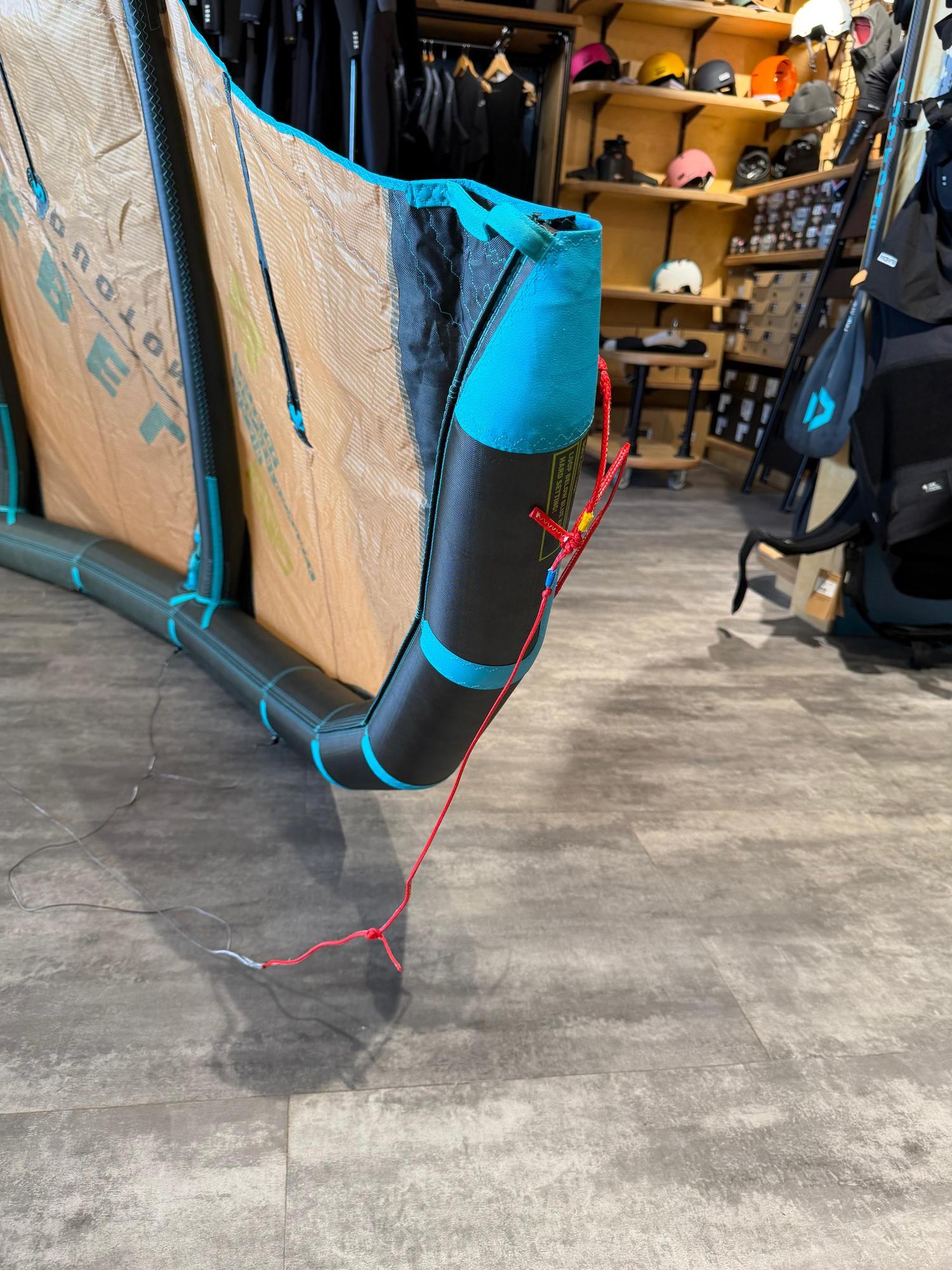 Used 8m Duotone Rebel SLS 2026 kite in black and teal with Penta TX material, showing wingtip detail and red pigtails.