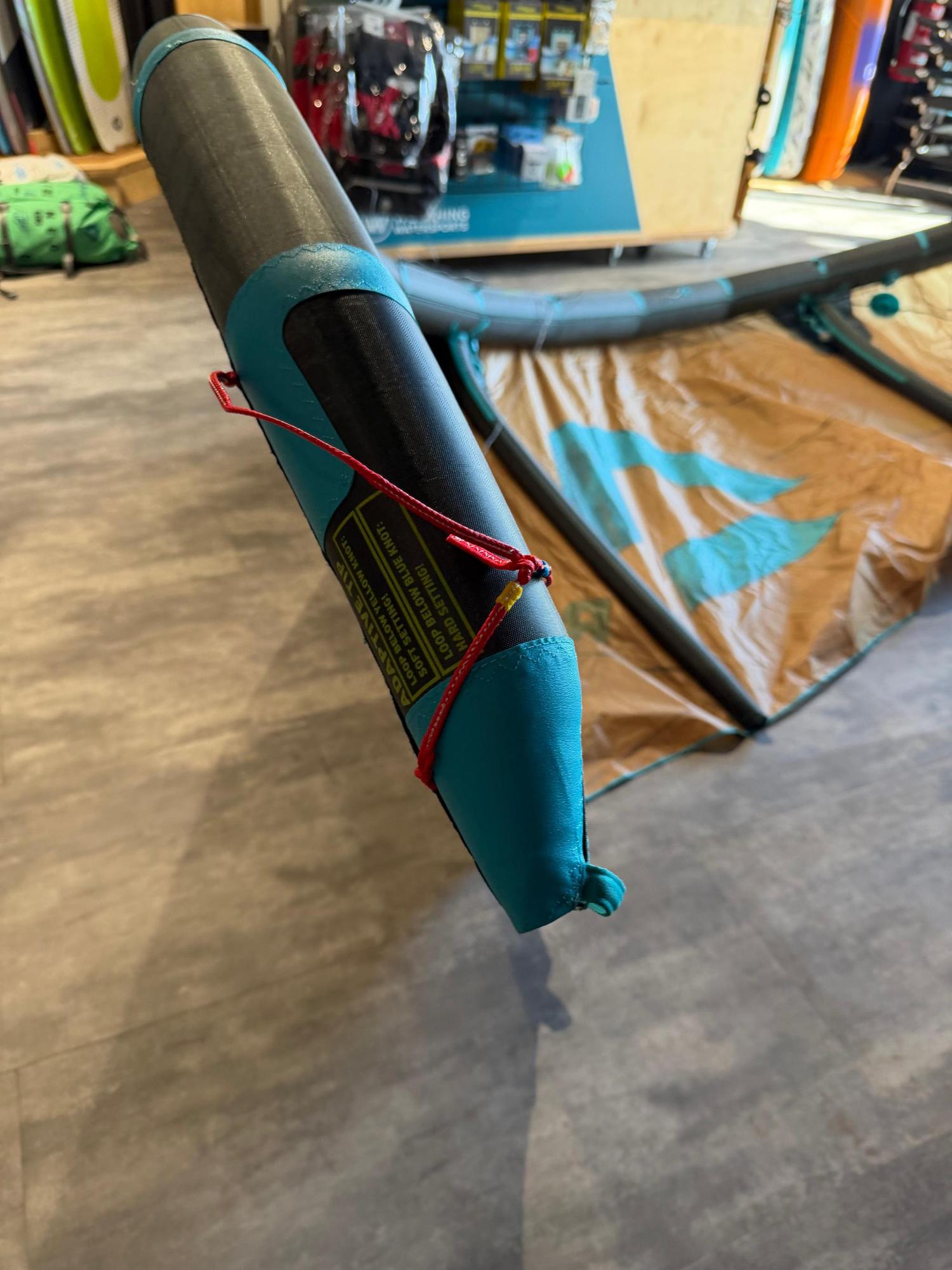 Close-up of a used 8m Duotone Rebel SLS kite wingtip featuring blue and black Penta TX material and adaptive tip settings.