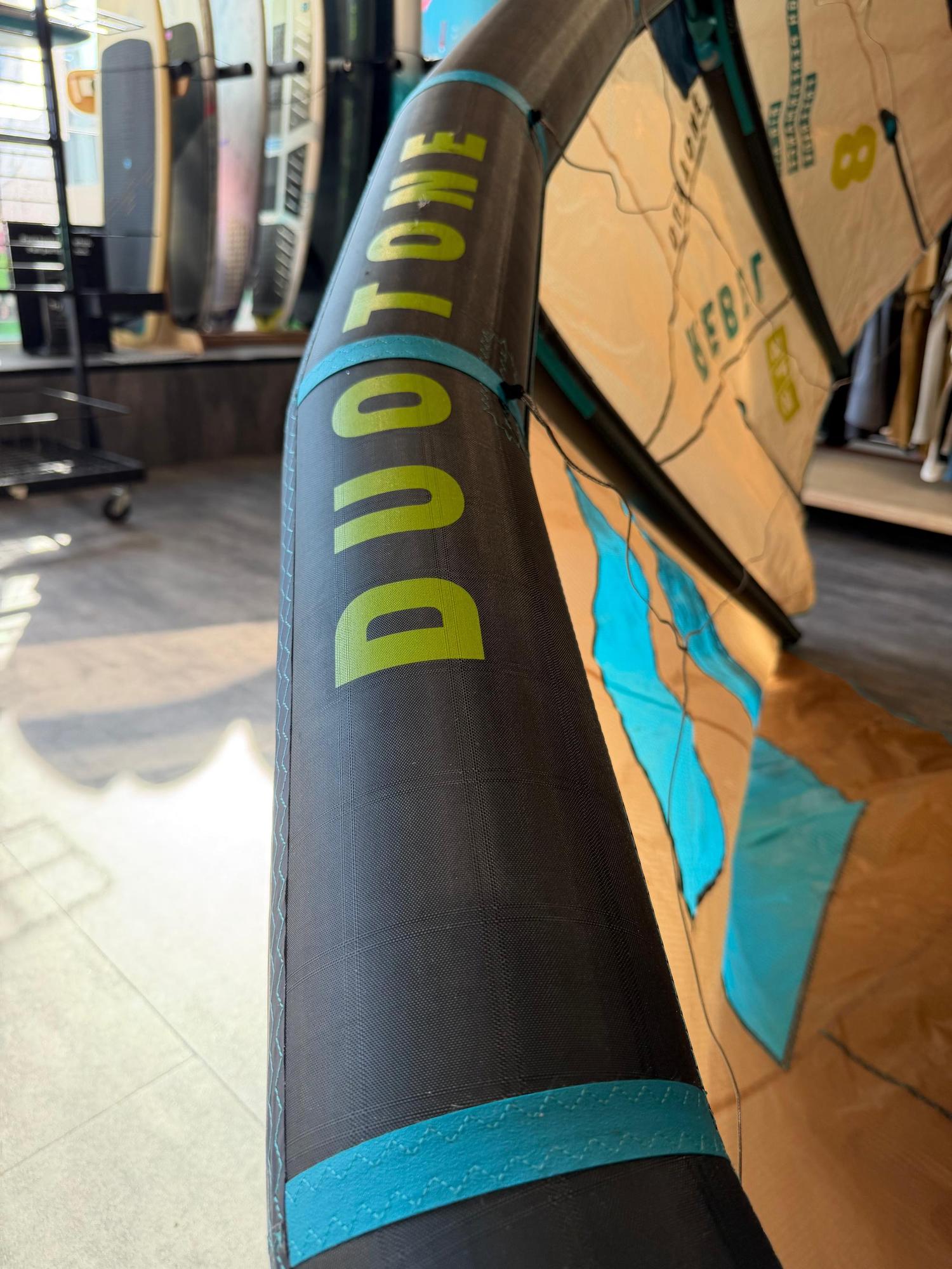 Used 8m Duotone Rebel SLS 2026 big air kite with black, blue, and tan fabric panels and bold green branding.