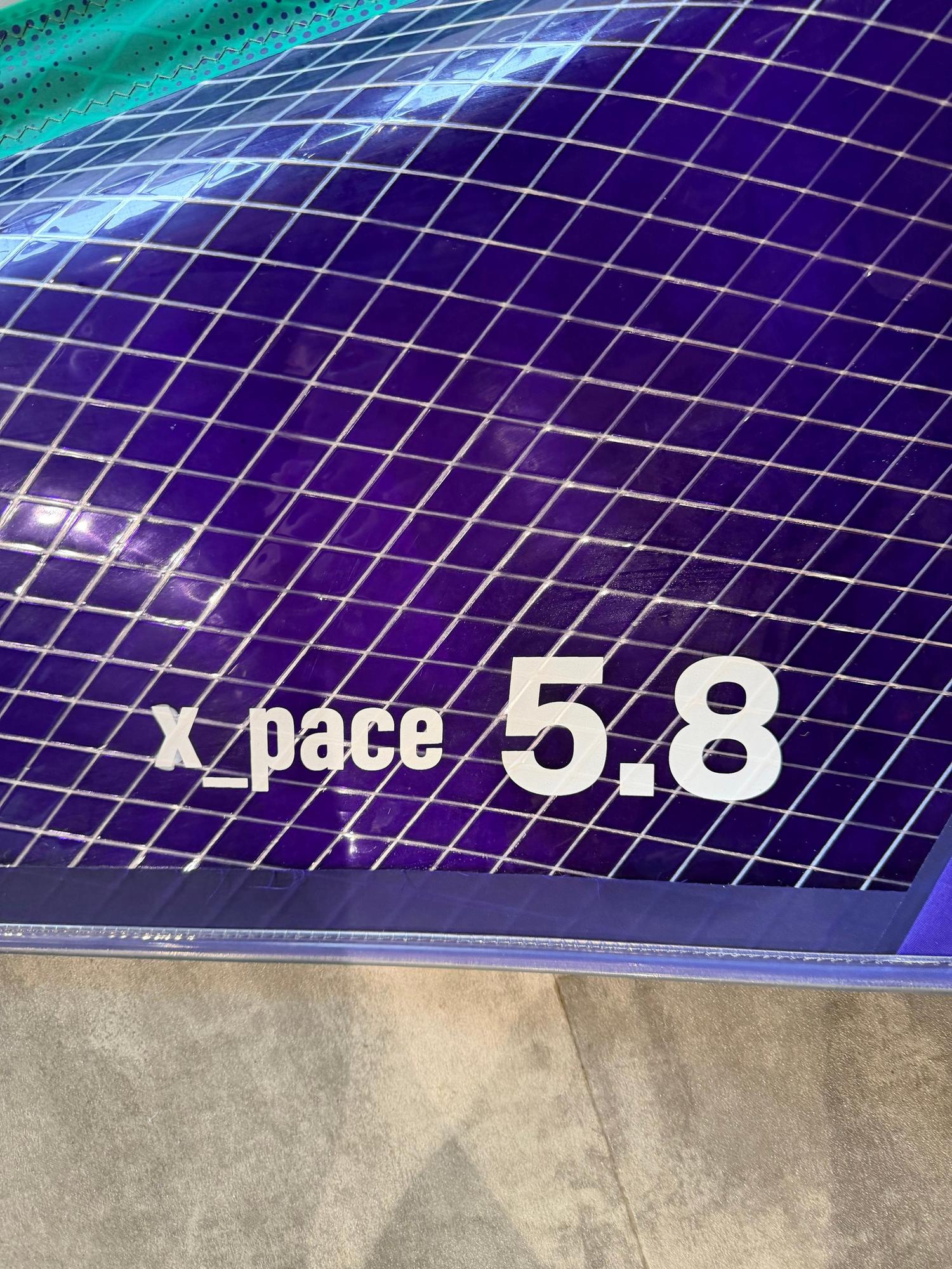 Purple Duotone X_Pace 5.8 freerace windsurf sail featuring a reinforced grid pattern and white branding text.