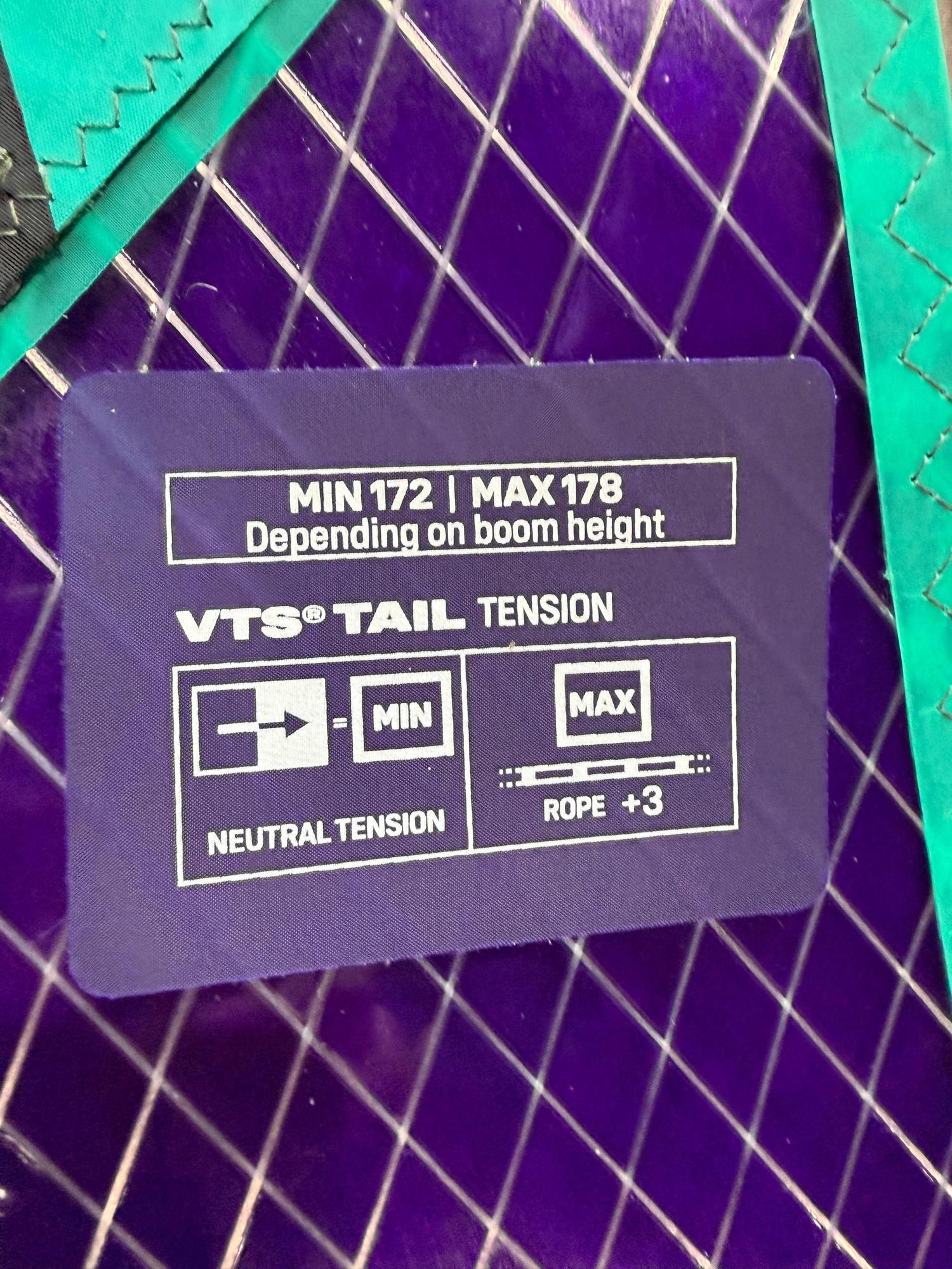 Duotone X_Pace windsurf sail VTS tail tension guide on a purple and teal sail panel with grid reinforcement.