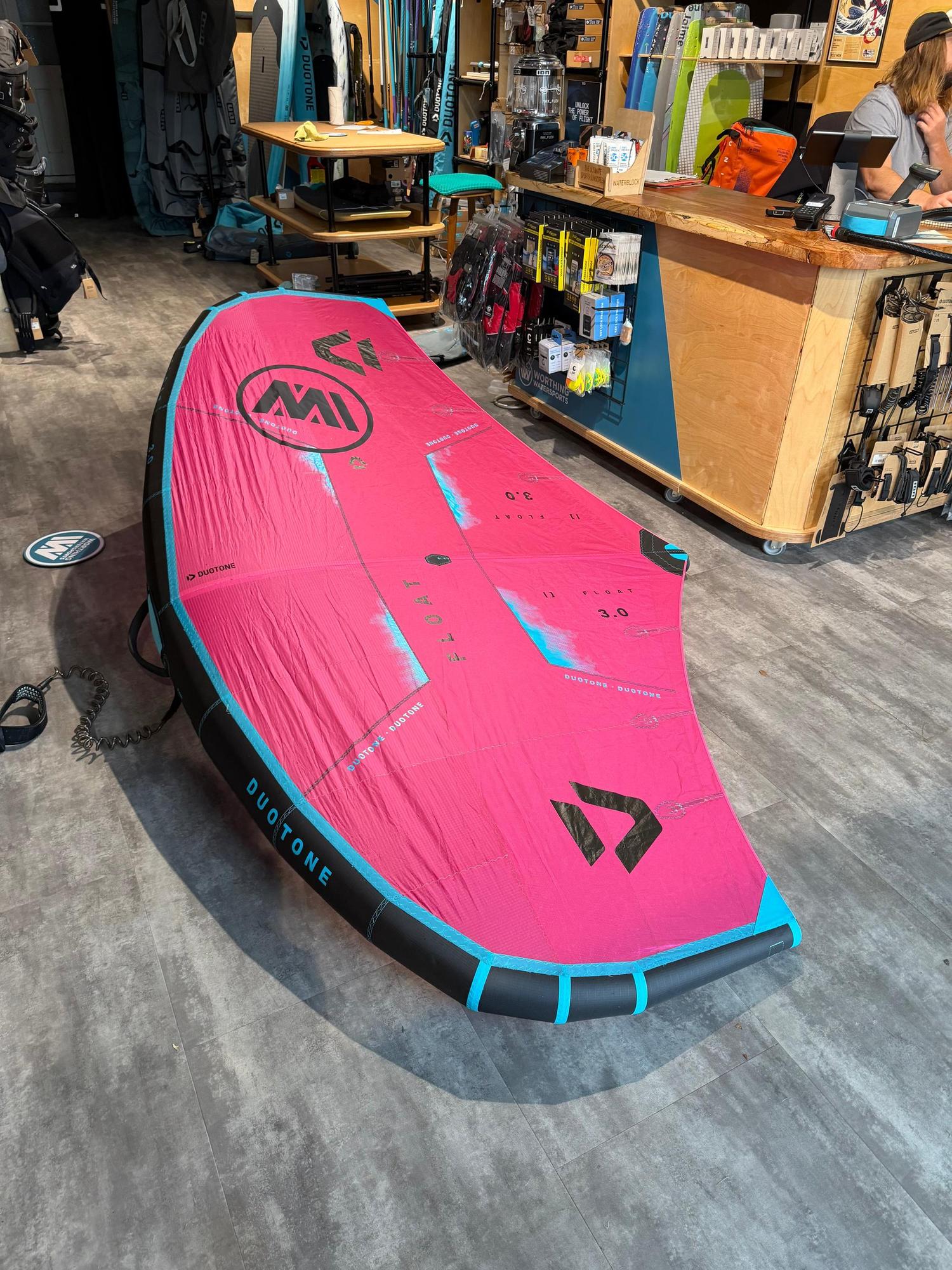 Used 3m Duotone Float wave wing in pink and black with a boom, displayed in a shop.