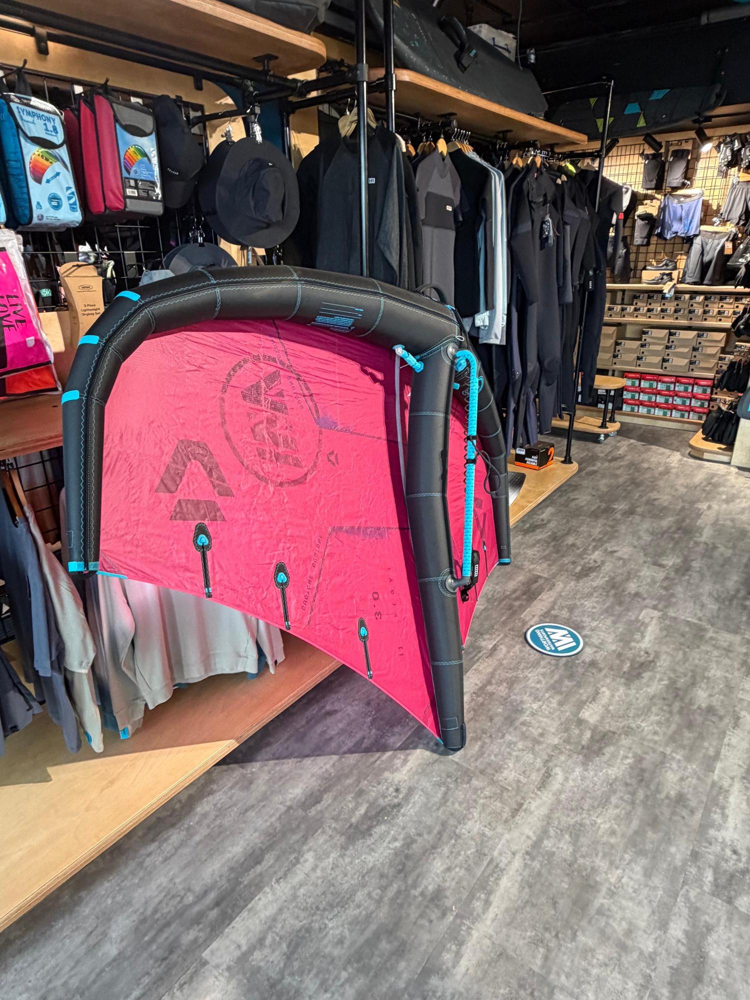 Used 3m Duotone Float wave wing in red and black with a boom, displayed in a retail store.