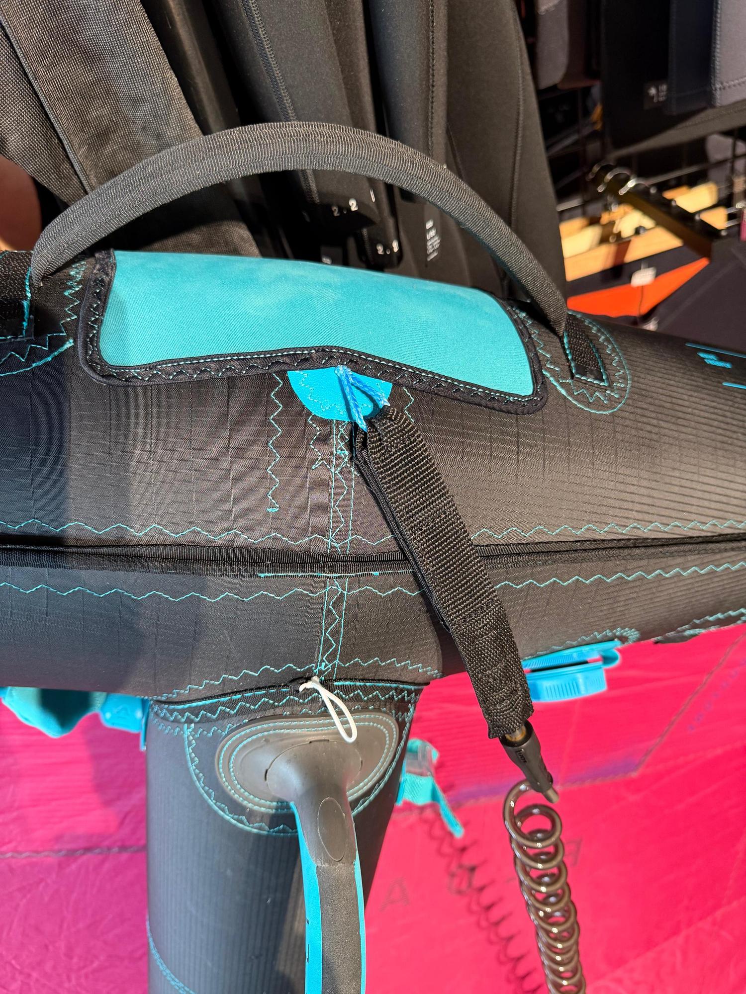 Used Duotone Float 3m wave wing in black with teal accents, featuring a central handle, boom attachment, and durable fabric.