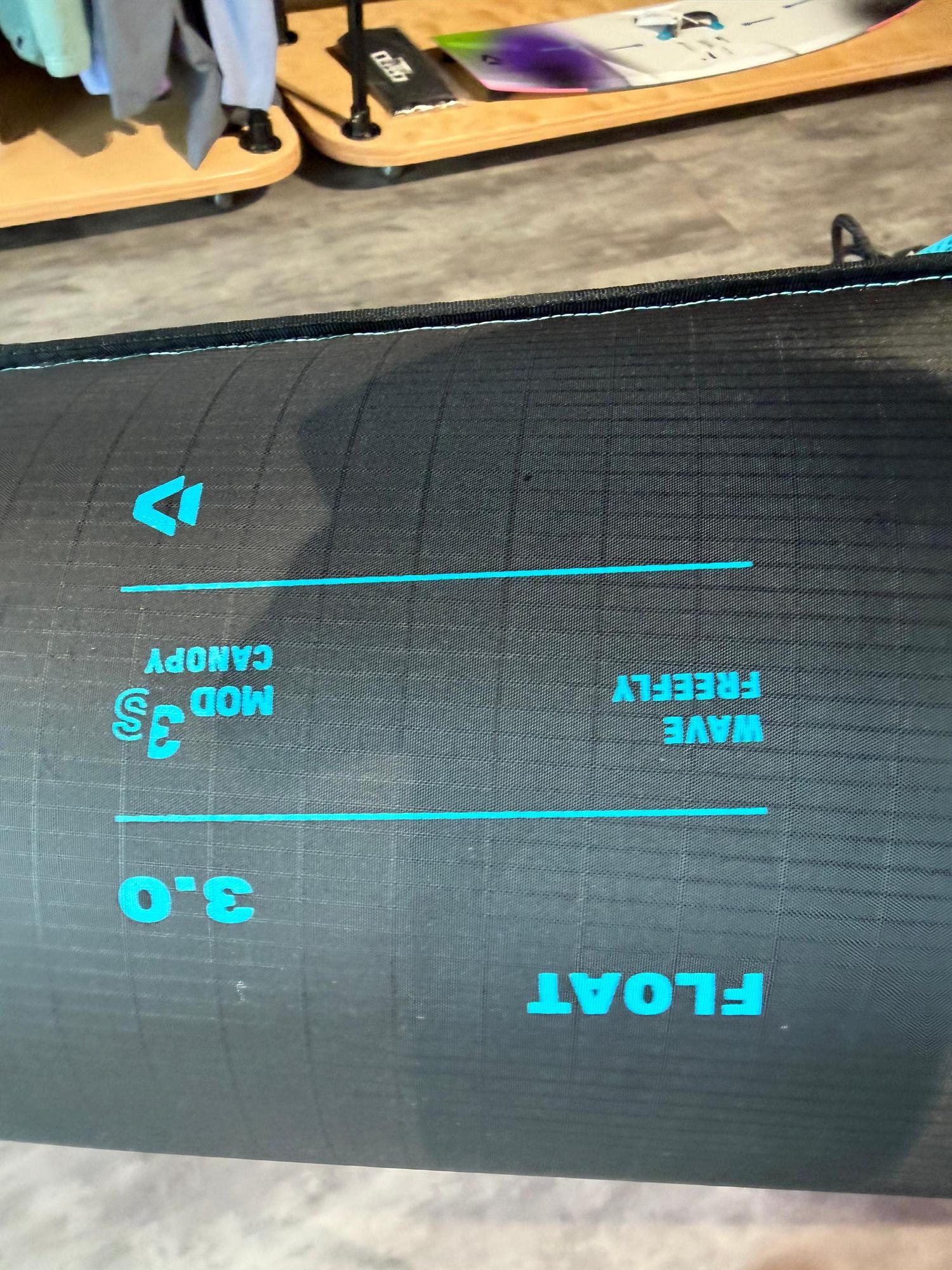 Black Duotone Float 3m wave wing with blue branding, Mod3 canopy fabric, and FreeFly text on a grid-patterned material.