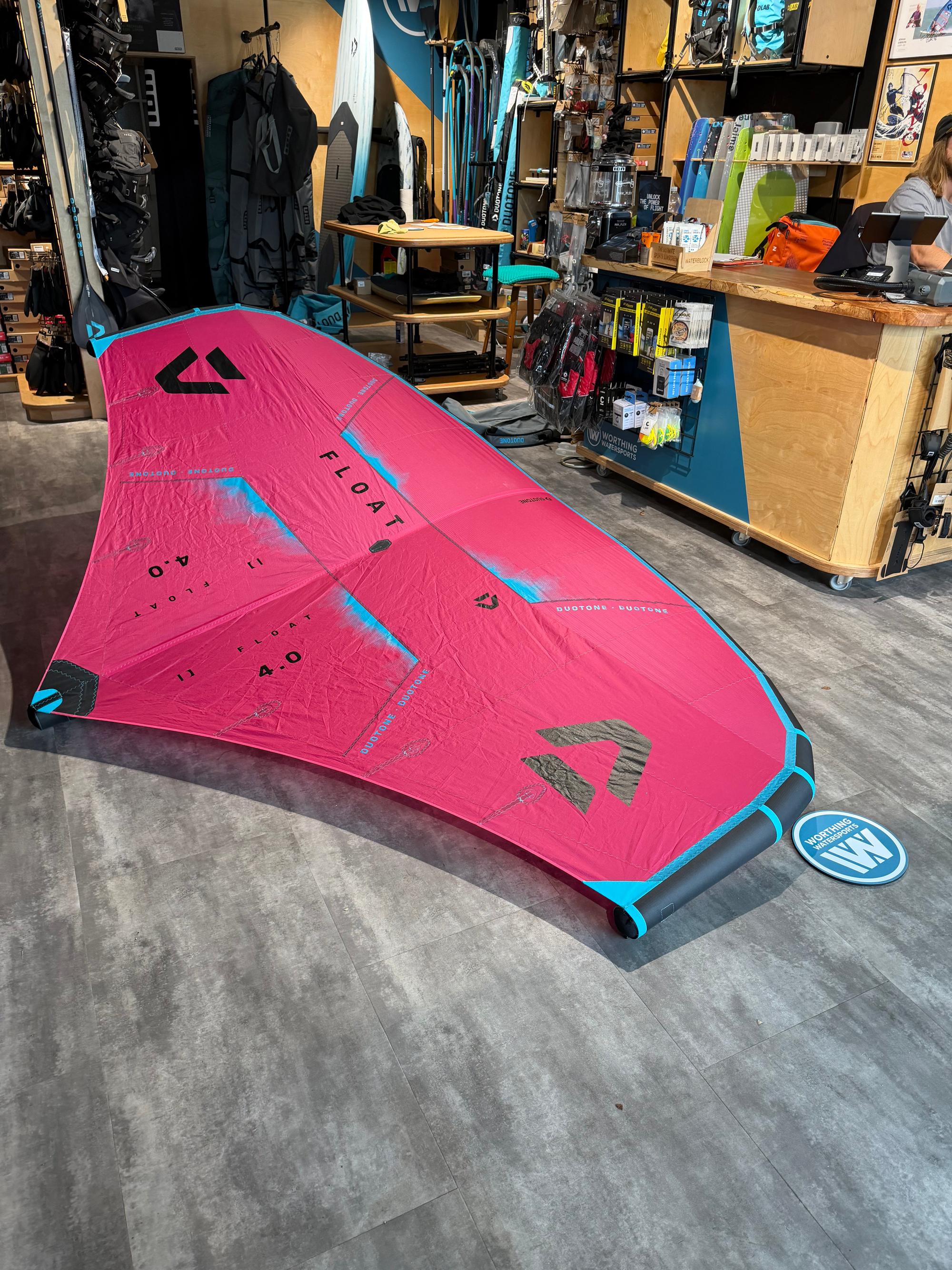 Used Duotone Float 4m wave wing in pink and blue, featuring a boom and lightweight canopy design for wave foiling.